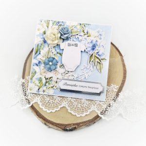 Ręcznie robiona kartka na chrzest chłopca. Niebieska kartka na chrzciny z motywem lilii oraz personalizowanym napisem. Wydruk życzeń w cenie.